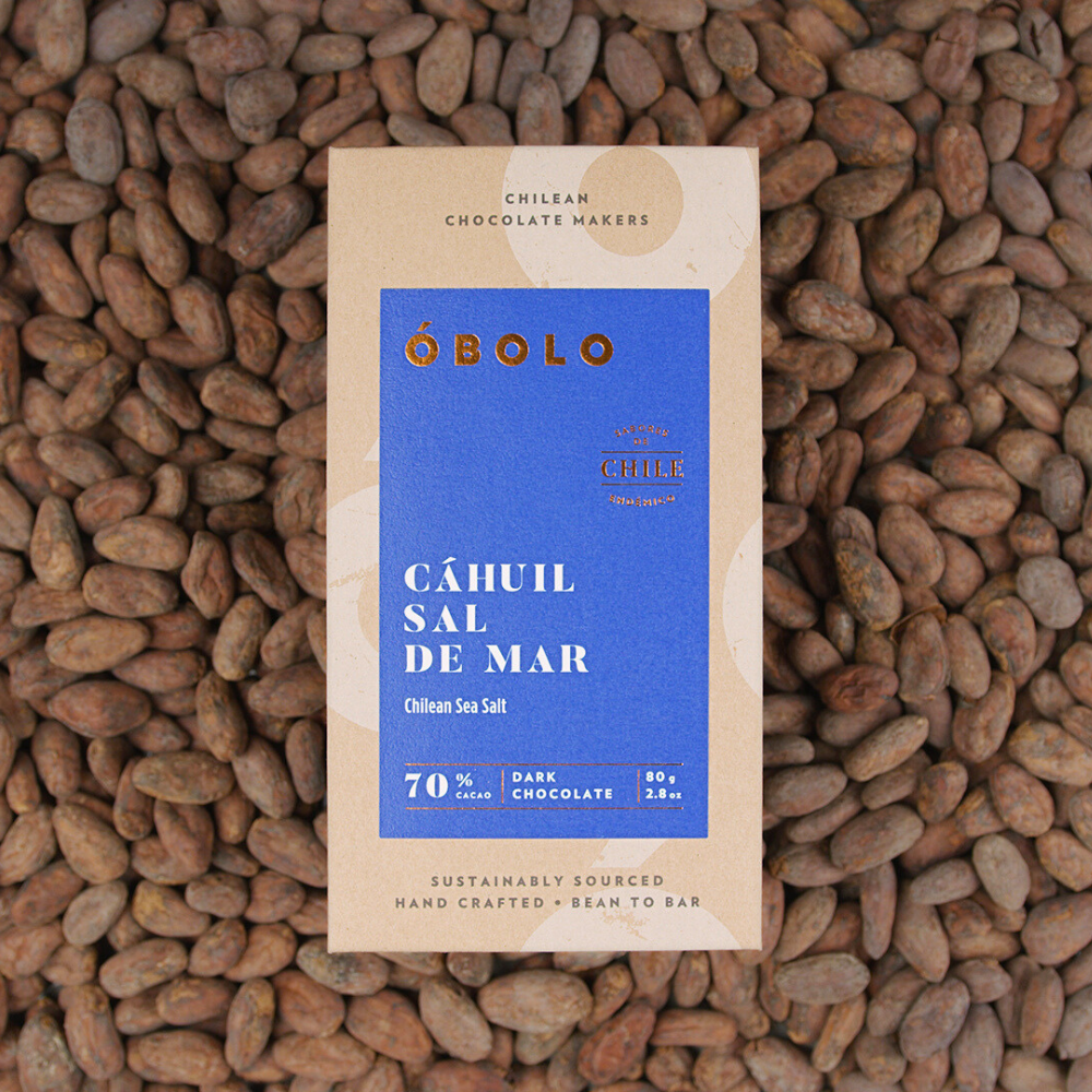 Barra chocolate 70% cacao con sal de mar envase reciclable sobre granos de cacao óbolo